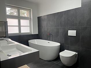 Badezimmer mit Badewanne und Dusche (rechts)