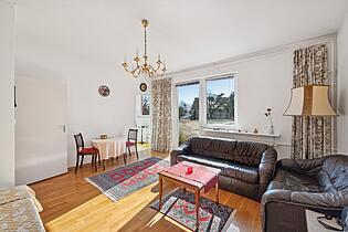 Wohnzimmer mit Zugang zum Balkon und zur Küche
